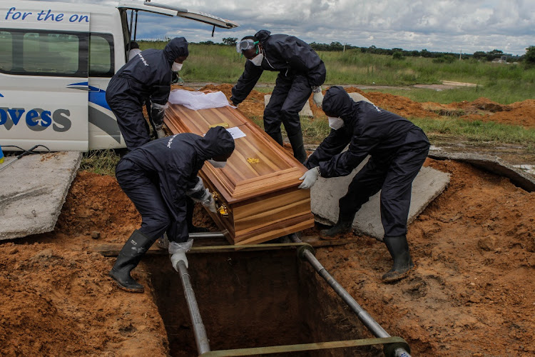 Funeral palour workers bury a Covid-19 victim. Picture: GETTY IMAGES/TAFADZWA UFUMELI