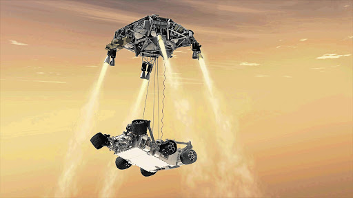 LANDING STAGE: This artist's impression shows the sky crane manoeuvre during the spacecraft's descent stage when, while controlling its own rate of descent with four of its eight throttle-controllable rocket engines, it has begun lowering the rover, Curiosity, onto the surface of Mars in the vast Gale crater Picture: REUTERS