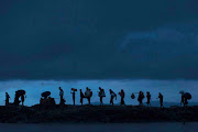 Rohingya refugees walk across Paddy fields at dusk after crossing the border from Myanmar on September 09, 2017 in Gundum, Bangladesh. Recent reports have suggested that around 290,000 Rohingya have fled Myanmar. Those who left have spoken of violence erupting in Rakhine state, when the country's security forces allegedly launched an operation against the Rohingya Muslim community. 