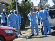 Crime scene investigators in front of the house where a woman allegedly killed her children, torched house and shot herself in Brakpan. 