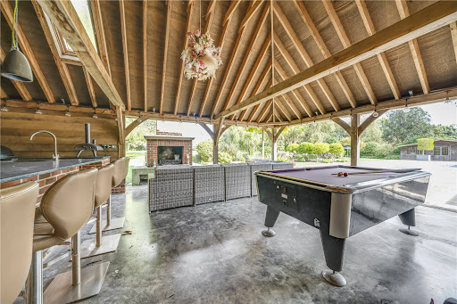 Outdoor bar with pool table and fireplace in this luxury house for sale in Flansham ($3,165,047)