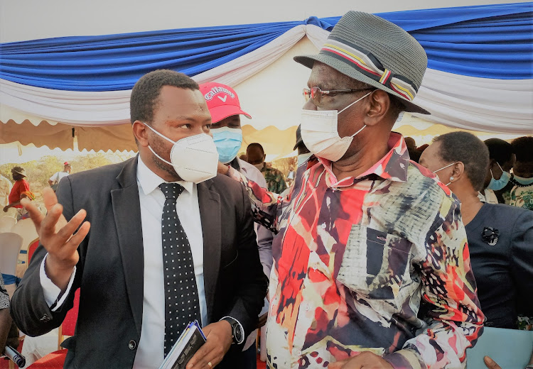 Former Wiper Party National chairman David Musila chats with Nairobi lawyer Kinengo Katisya during a burial in Mwingi North, Kitui county.