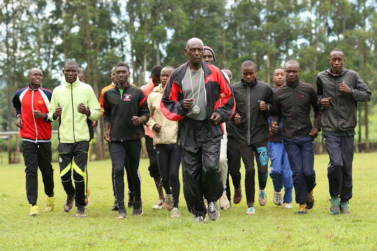 Retired athlete Peter Kianga jogs with junior athletes at Kiandege athletics training camp in Nyamira