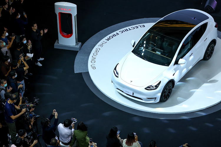 Members of media and guests surround the Tesla Model Y during Thailand Tesla's official launch event in Bangkok, Thailand, in December 2022. Picture: REUTERS