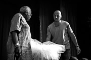 Archbishop Emeritus Desmond Tutu with photographer Adrian Steirn and the ballet tutu used for the 21 Icons South Africa photo shoot