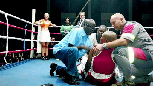 It was tragedy at HTS Garden Hall in Pretoria when Phindile Mwelase was knocked down in the sixth round by Liz Butler and went into coma which she could not overcome and later died in hospital. Here doctor Solly Skosana (blue shirt), her trainer Stanley Ndlovu and a paramedic examined her. PHOTO: Pumeza Zinakie