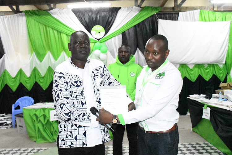 The MP-elect receives his certificate from Teso North returning officer Andrew Wetende after being declared winner at 2am on Thursday August 11