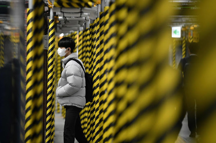 A man wearing a face mask walks between columns at a subway station being renovated in Seoul,South Korea.