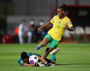 Noxolo Cesane of South Africa challenged by Tunisia goalkeeper Jebrani Soulaima during the 2022 Womens Africa Cup of Nations quarterfinal match between South Africa and Tunisia at Stade Prince Moulay Al Hassan, Rabat.