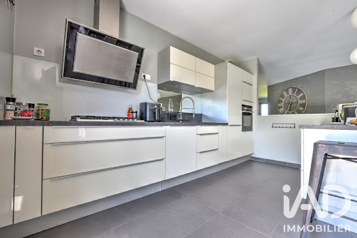 Modern kitchen with white lacquered cabinets in this luxury property for sale in Rilhac-Rancon ($618,269 - 232 m²)