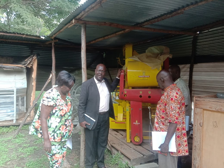 Kisumu Agriculture executive Gilchrist Okuom and other officials inspect the ginnery machine