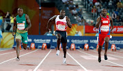 Harry Aikines-Aryeetey of England, Kemar Hyman of Cayman Islands and Akani Simbine of South Africa compete in the Men's 100m Semifinal 3 at the Carrara Stadium in the 2018 Commonwealth Games in Australia on April 8 2018.