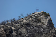 A Greek national flag flutters atop a burned hilltop following a wildfire, near the village of Avantas in the region of Evros, Greece, August 28, 2023. 