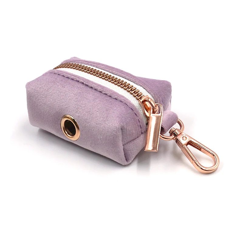 Distributeur de sacs à déjections pour animaux en velours doux. Élégant et discret, facile à utiliser et à recharger, pour des promenades propres et stylées.