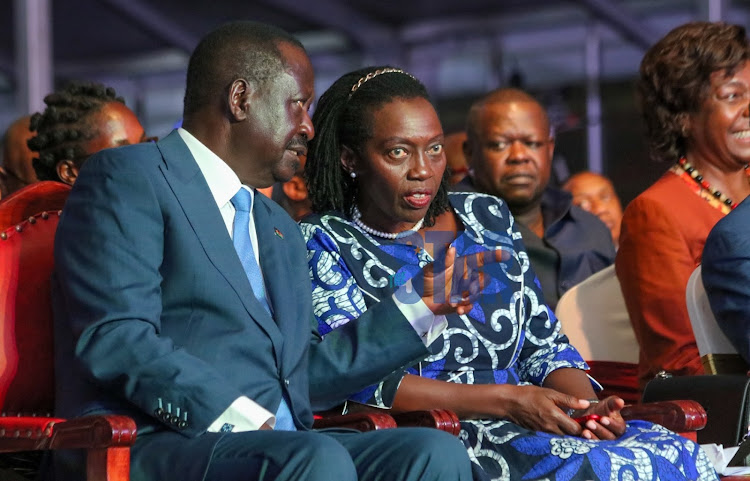 Azimio la Umoja Presidential candidate Raila Odinga,and running mate Martha Karua confer during the launch of the coalition's manifesto.