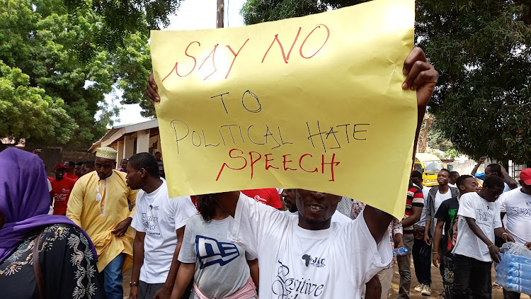 Youths hold placards with peace messages in Kwale county on Saturday