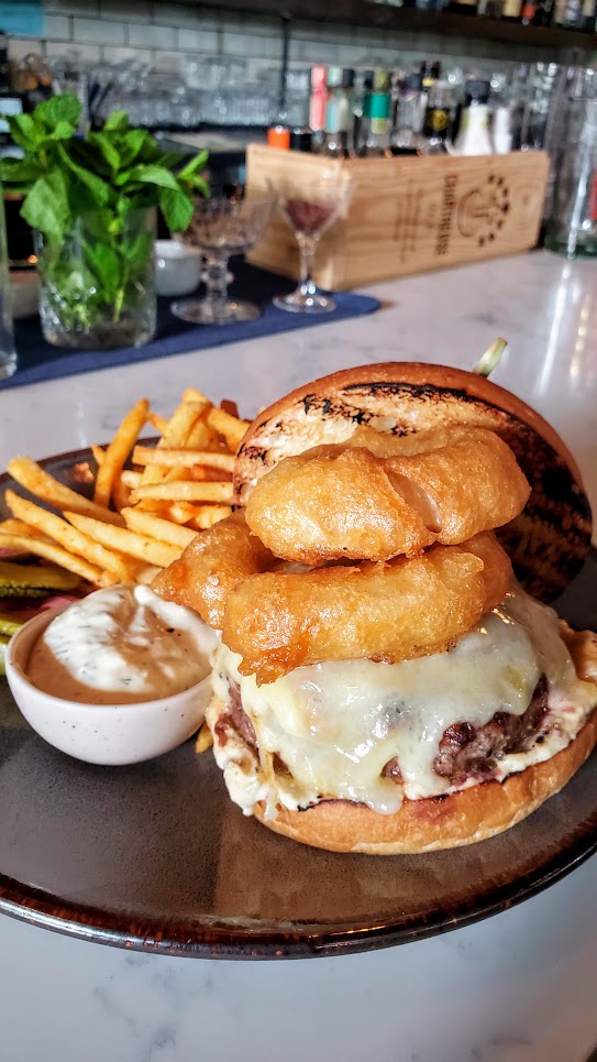 Normandie PDX Burger on Briochea with famous 5 Hour Onions, Alpine Cheeses, and Mustard Aioli