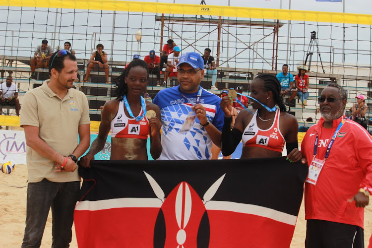 Gaudencia Makokha, Naomi Too parade their bronze medal as KVF chairman Waithaka Kioni (R) looks on