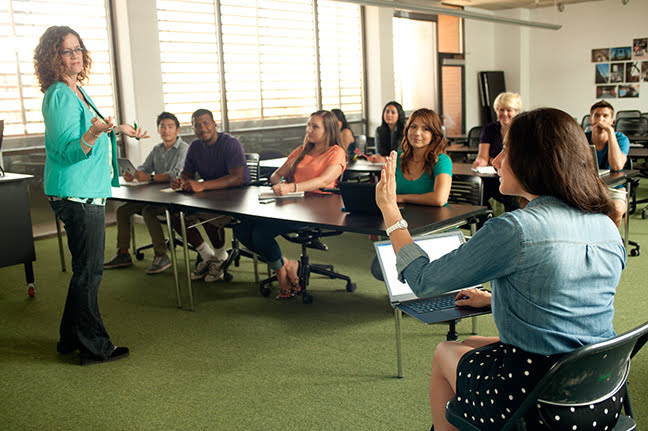 transcriber asking instructor question in class as students observe