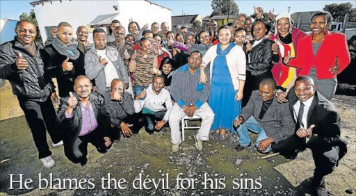 Pastor Zakhele Ntiwane (seated) is surrounded by many of those he welcomed into his home as children from 1998 when he moved to East London Picture: MARK ANDREWS