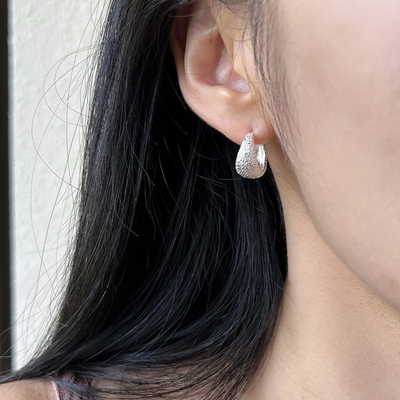 Fluweel zilver wit waterdruppel dun en glinsterend mat oorclip. Voeg een vleugje glamour toe aan je outfit voor een subtiele elegantie.