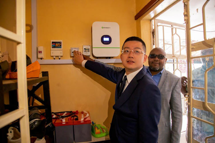 Mr. Ma Chengyuan, Chief Representative of AVIC International Holding Corporation in Kenya accompanied by Mutuini MCA Mr. Martin Mbugua switch on the solar system at at Shiphrah Children Centre in Mutuini Ward, Dagoretti South constituency in Nairobi.