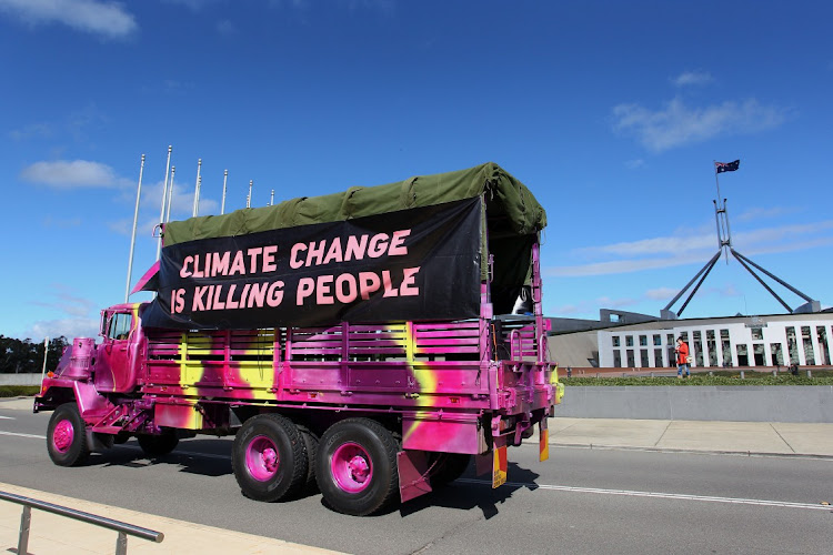 A vehicle signed passes by Parliament House in Canberra, Australia. Picture: GETTY IMAGES/LISA MAREE WILLIAMS