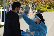 A spectator takes a nasal swap coronavirus test at a mobile Covid-19 testing site at SoFi Stadium during the game between the Los Angeles Chargers and the Denver Broncos.