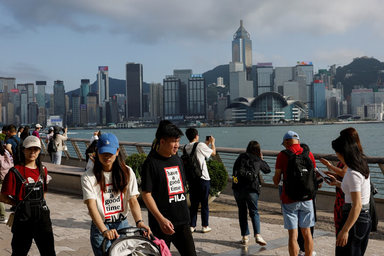 Mainland Chinese tourists walk in front of the skyline of buildings at Tsim Sha Tsui, in Hong Kong, May 2 2023. Picture: TYRONE SIU/REUTERS