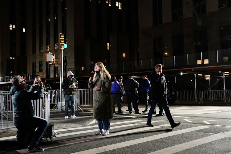 A media reporter records a live television spot outside Manhattan Criminal Court after former US President Donald Trump's indictment by a Manhattan grand jury following a probe into hush money paid to porn star Stormy Daniels, in New York City, New York, US, March 30, 2023.