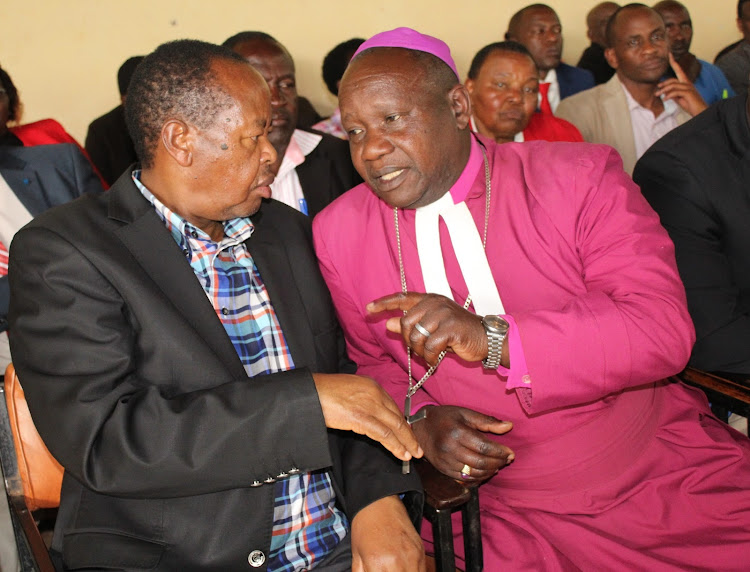 Nyeri Senator Ephraim Maina consults Anglican Church Mt Kenya West Diocese Bishop Joseph Kagunda during a meeting for grassroots and church leaders at Nyamachaki PCEA hall in Nyeri town on Monday.