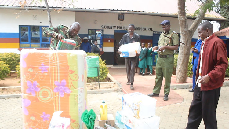 Mwingi police officers led by subcounty police commander Peter Mutuma donate beddings and food stuffs to the three orphaned sisters at Mwingi on Tuesday, June 21.