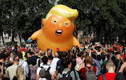  Onlookers stand in front of a blimp portraying U.S. President Donald Trump, in Parliament Square, during the visit by Trump and First Lady Melania Trump in London, Britain July 13, 2018. 