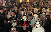 Activists wearing masks showing China's jailed Nobel laureate Liu Xiaobo during a night vigil in Liberty Square, in Taipei, yesterday on the 24th anniversary of the 1989 crackdown on pro-democracy protesters in Tiananmen Square, Beijing