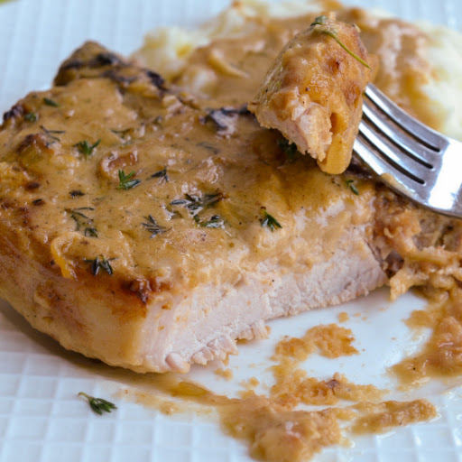 Southern style breaded pork chops are smothered with a rich cream gravy seasoned with caramelized onions and garlic. Serve over mashed potatoes, rice, or egg noodles.