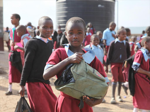 A schoolgirl poses for a photo outside a school in Kajiado on July 21, 2017.