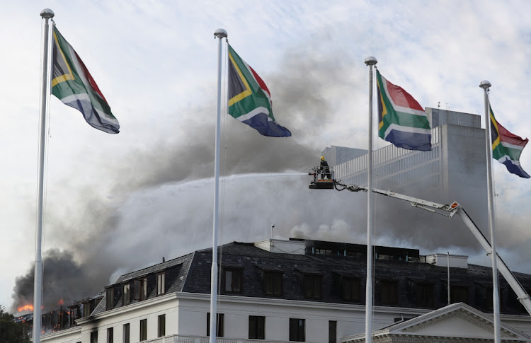 Firefighters at work at the national parliament in Cape Town after the fire flared up again.