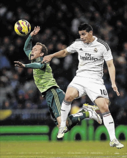 INJURED: Real Madrid's James Rodriguez, right, fights for the ball with Celta Vigo's Michael Krohn-Dehli in Saturday's La Liga match in Madrid PHOTO: Andrea Comas/REUTERS