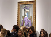 Christie's employees stand in front of an artwork titled 