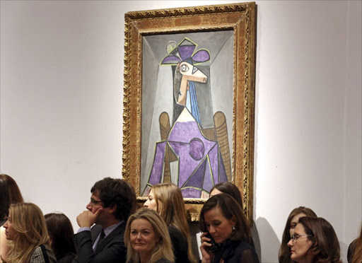 Christie's employees stand in front of an artwork titled "Portrait de femme (Dora Maar)" by artist Pablo Picasso during a Christie's auction in New York. REUTERS/Adam Hunger