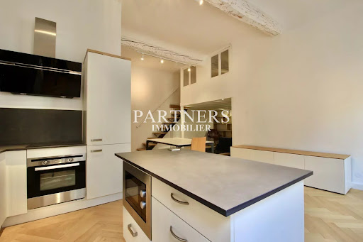 Modern kitchen with island and staircase in this luxury apartment / penthouse for sale in Aix-en-Provence ($467,131 - 55 m²)