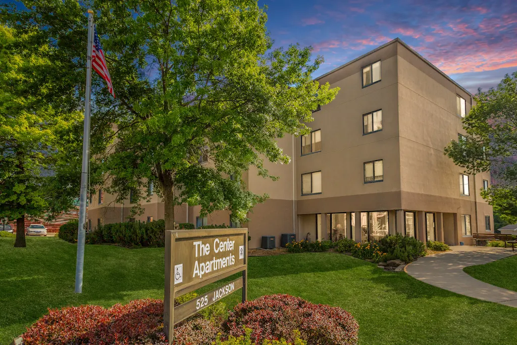 The Center apartment building with light exterior at dusk