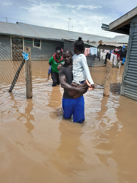 Children displaced after backflow from Lake Victoria caused flooding in Dunga in Nyalenda B ward, Kisumu Central are helped by CCF officers on Sunday.