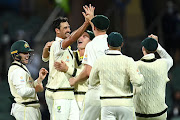 Mitchell Starc of Australia celebrates with team mates after taking the wicket of Joe Root of England for 24 runs during day four of the Second Test match in the Ashes series at the Adelaide Oval on December 19, 2021