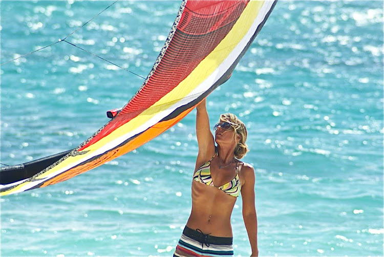 A woman preps to go kitesurfing in the surf in Mexico.