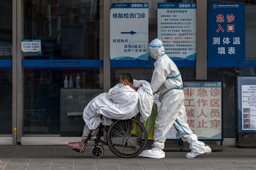 A health worker pushes a patient in a wheelchair at a hospital in Beijing, China, on December 14 2022. Picture: BLOOMBERG