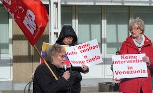 Demonstrantinnen mit Plakaten «Keine Intervention in Venezuela», Uwe Koopmann mit DKP-Fahne und Mikrofon.