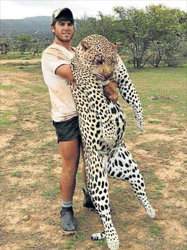 ENDANGERED: Burchell’s Private Game Reserve vermin control officer Dale Venske holds the leopard he shot dead after it mauled the reserve’s houndsman Zwelake Dyan on an expedition to hunt jackal and lynx Picture: SUPPLIED