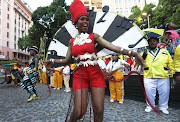 Sihle Ngantweni of the Greenmarket Hub leads dancers during the  Cape Town Carnival. 