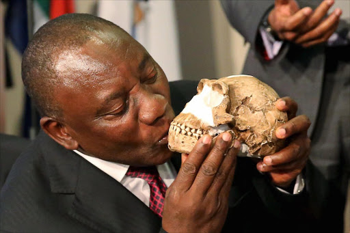 Deputy President Cyril Ramaphosa kisses a replica of the skull of a newly discovered ancient species, named Homo naledi, during its unveiling. Picture: FILE